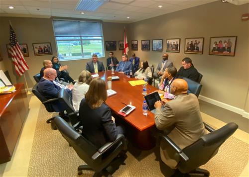 Eric Terrell at head of conference table with principals 